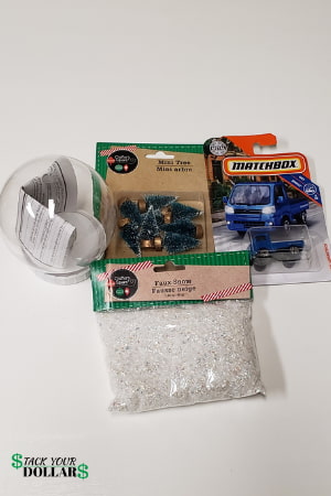 Faux snow, toy truck, Christmas tree ornament, and plastic snow globe